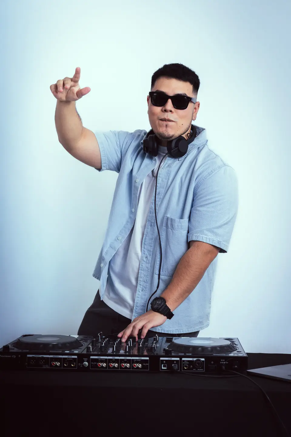DJ Real señalando hacia arriba mientras mezcla