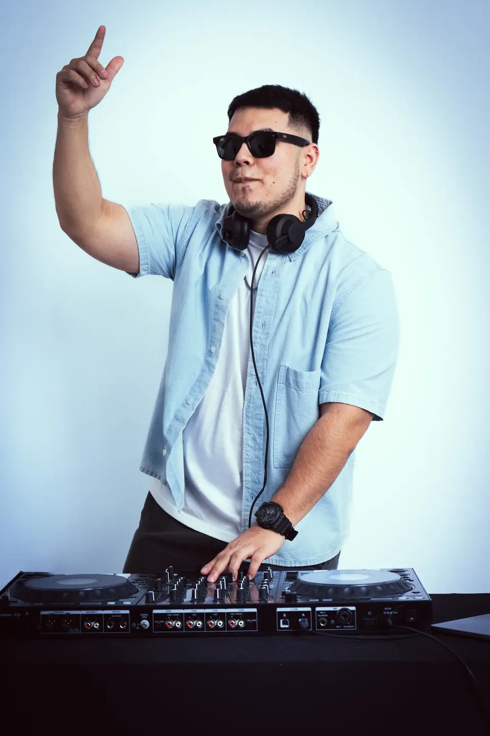 DJ Real con la mano en alto detrás de la controladora